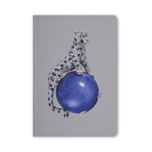 The cover of this pocket-sized blank notebook is grey with a reproduction of a Cartier brooch design; a diamond panther seated on a large spherical sapphire