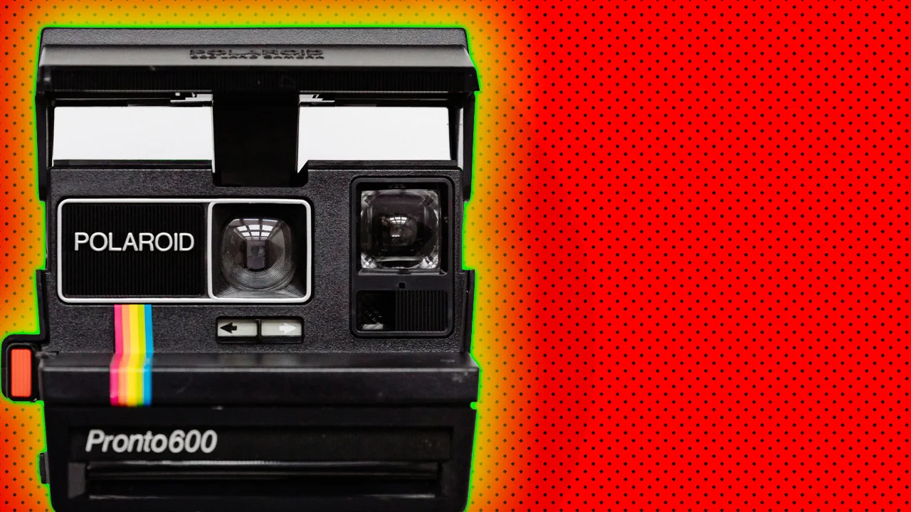 A photo of a black polaroid camera with the classic rainbow stripe against a red dotted background with yellow halo.